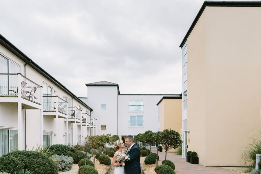 bride and groom in courtyard at Quay hotel and spa wedding again