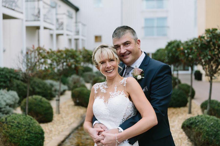 smiling bride and groom in courtyard at Quay hotel and spa wedding
