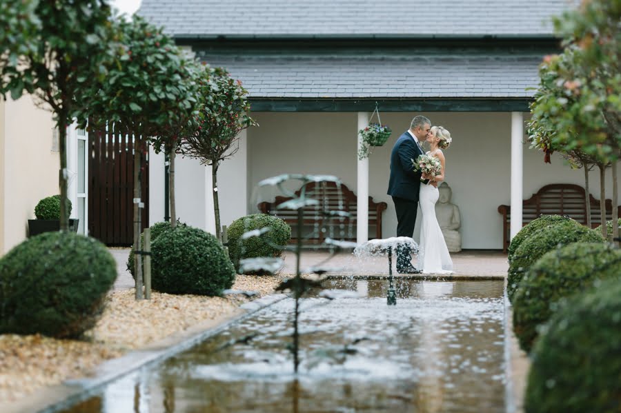 bride and groom in courtyard with water feature at Quay hotel and spa wedding