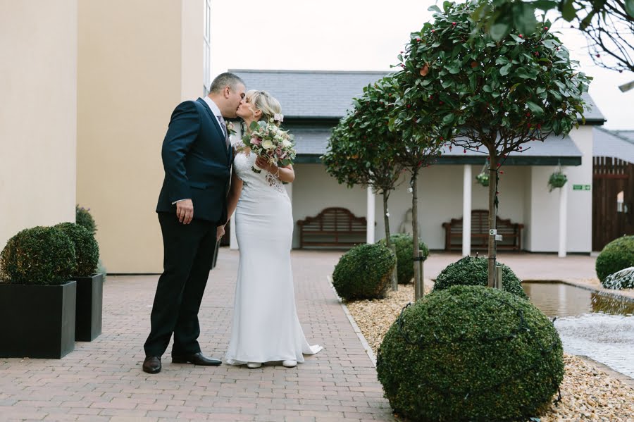 bride and groom kissing in courtyard at Quay hotel and spa wedding
